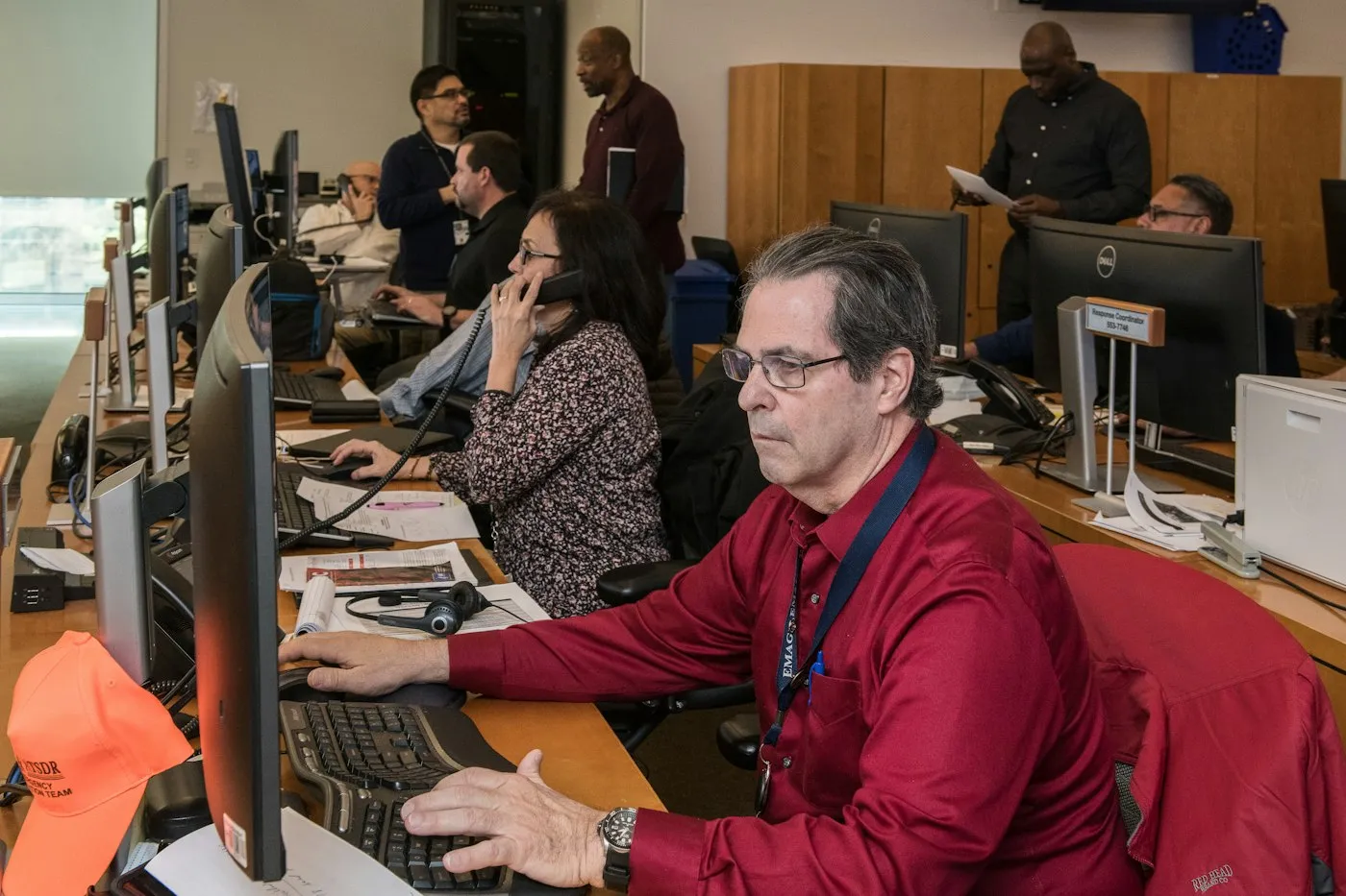 People working at a row of desks and monitors in an operations room