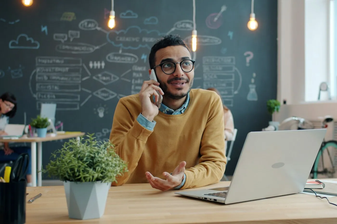 A salesperson on a phone call at a desk with an open laptop