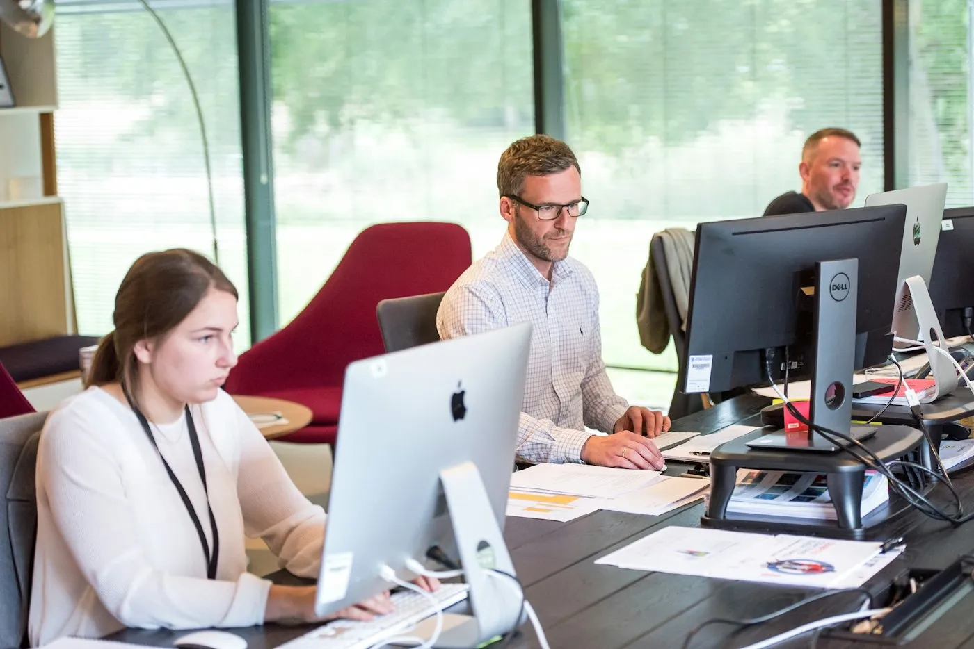 A support team working at their desks in a bright office